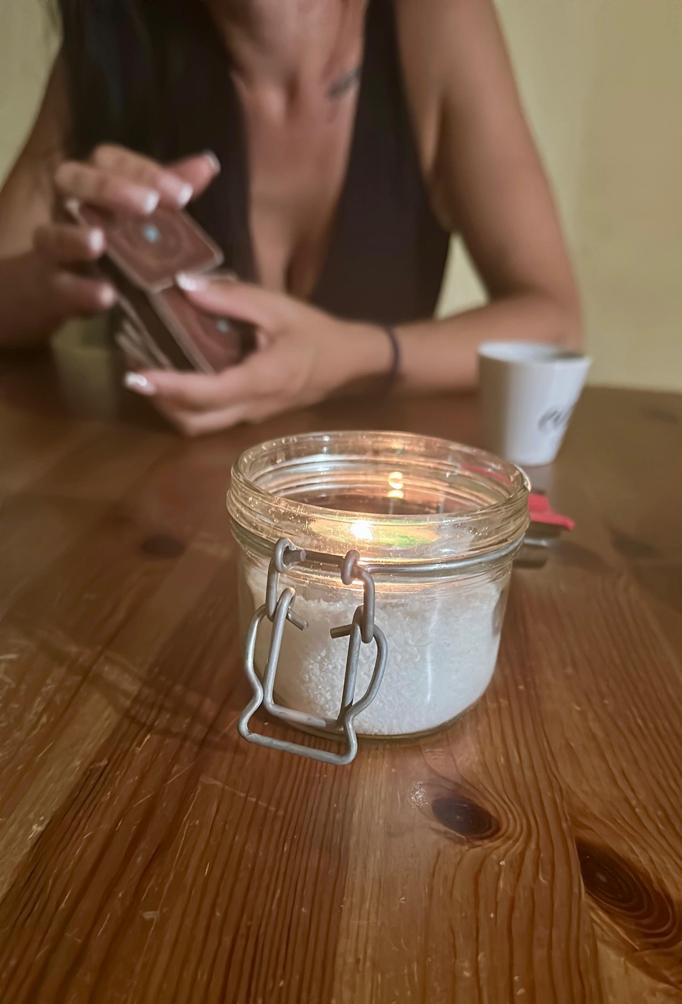 Valentina mentre mescola le carte dei Tarocchi, con una candela accesa sul tavolo